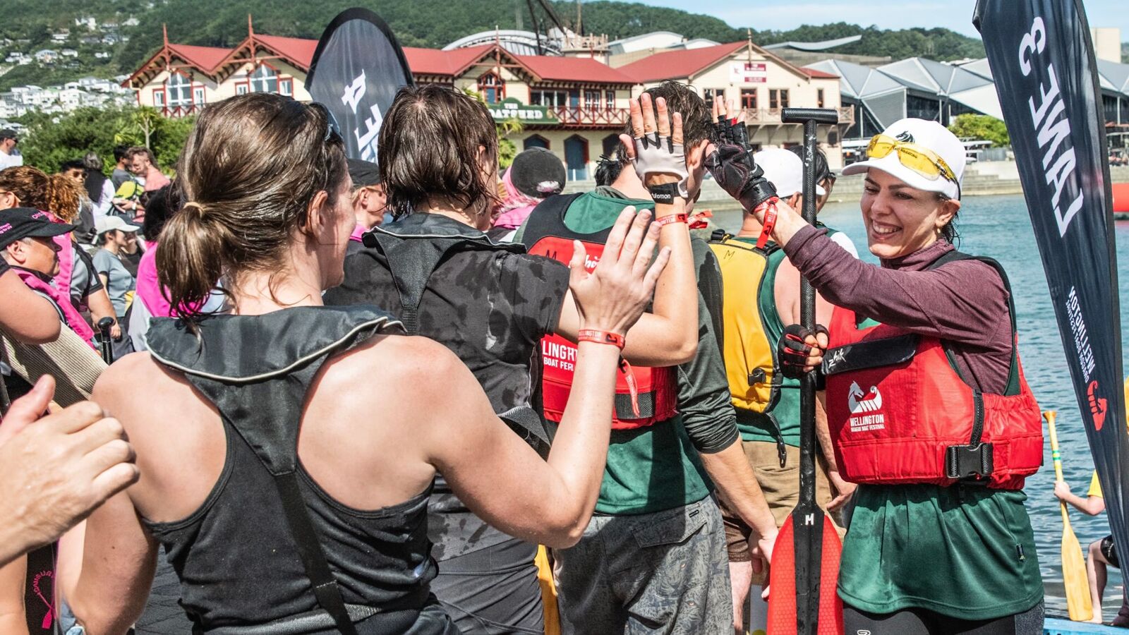 Teammates high-fiving on the wharf after a dragon boat race
