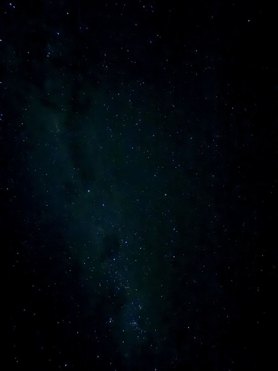 A star-filled night sky with a faint Milky Way